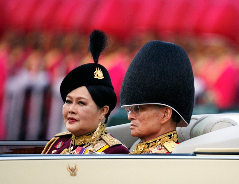 THAILAND-QUEENMOTHER/ FILE PHOTO: Britain's Queen Elizabeth II smiles as she greets Thailand's Queen Sirikit as the King Bhumibol Adulyadej looks on at a reception at the British Ambassador's residence in central Bangkok, Thailand October 30, 1996. REUTERS/Dylan Martinez/File Photo