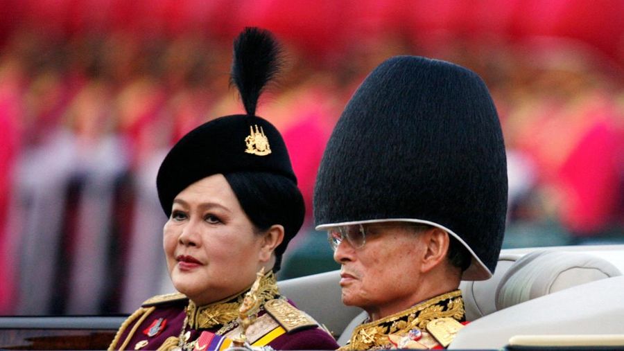 THAILAND-QUEENMOTHER/  Britain's Queen Elizabeth II smiles as she greets Thailand's Queen Sirikit as the King Bhumibol Adulyadej looks on at a reception at the British Ambassador's residence in central Bangkok, Thailand October 30, 1996. REUTERS/Dylan Martinez/File Photo