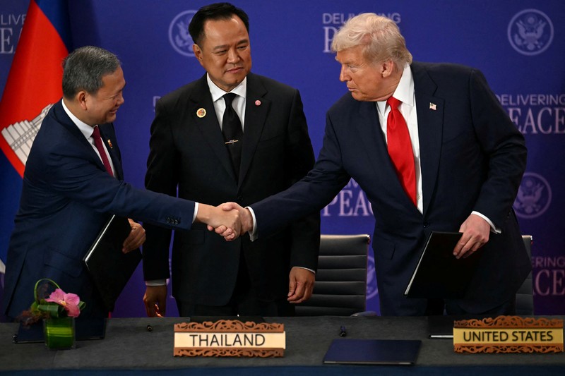 Perdana Menteri Thailand Anutin Charnvirakul dan Perdana Menteri Kamboja Hun Manet berjabat tangan di samping Presiden AS Donald Trump, pada hari penandatanganan kesepakatan gencatan senjata antara Kamboja dan Thailand di sela-sela KTT ke-47 Perhimpunan Bangsa-Bangsa Asia Tenggara (ASEAN) di Kuala Lumpur, Malaysia, 26 Oktober 2025. REUTERS/Evelyn Hockstein