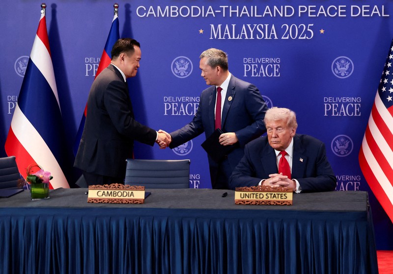 Perdana Menteri Thailand Anutin Charnvirakul dan Perdana Menteri Kamboja Hun Manet berjabat tangan di samping Presiden AS Donald Trump, pada hari penandatanganan kesepakatan gencatan senjata antara Kamboja dan Thailand di sela-sela KTT ke-47 Perhimpunan Bangsa-Bangsa Asia Tenggara (ASEAN) di Kuala Lumpur, Malaysia, 26 Oktober 2025. REUTERS/Evelyn Hockstein