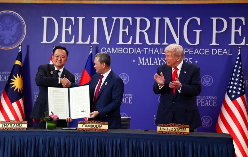 Perdana Menteri Thailand Anutin Charnvirakul dan Perdana Menteri Kamboja Hun Manet berjabat tangan di samping Presiden AS Donald Trump, pada hari penandatanganan kesepakatan gencatan senjata antara Kamboja dan Thailand di sela-sela KTT ke-47 Perhimpunan Bangsa-Bangsa Asia Tenggara (ASEAN) di Kuala Lumpur, Malaysia, 26 Oktober 2025. REUTERS/Evelyn Hockstein