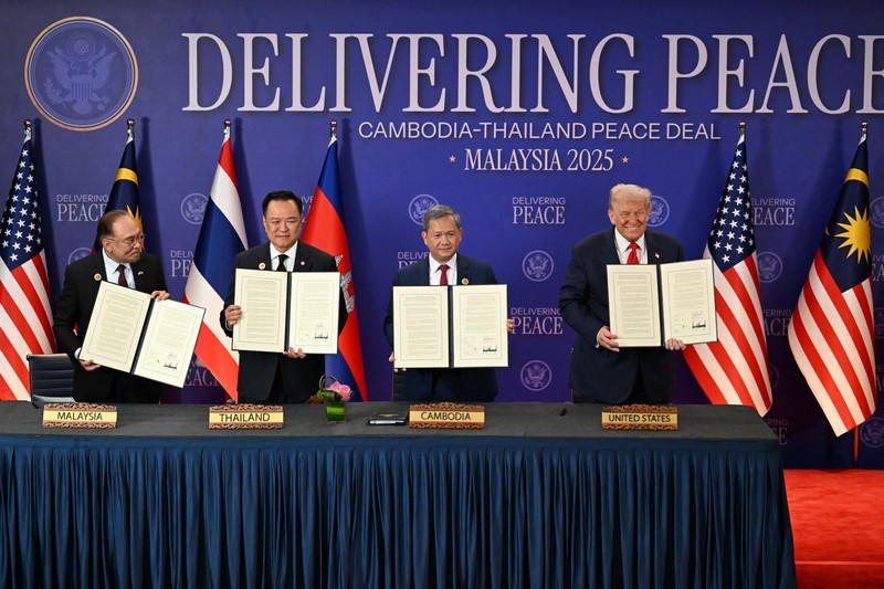 Perdana Menteri Thailand Anutin Charnvirakul dan Perdana Menteri Kamboja Hun Manet berjabat tangan di samping Presiden AS Donald Trump, pada hari penandatanganan kesepakatan gencatan senjata antara Kamboja dan Thailand di sela-sela KTT ke-47 Perhimpunan Bangsa-Bangsa Asia Tenggara (ASEAN) di Kuala Lumpur, Malaysia, 26 Oktober 2025. REUTERS/Evelyn Hockstein