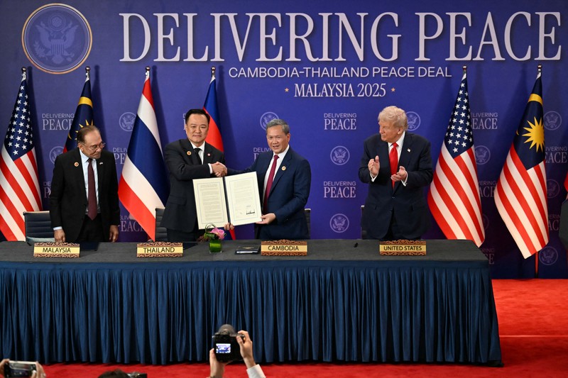 Perdana Menteri Thailand Anutin Charnvirakul dan Perdana Menteri Kamboja Hun Manet berjabat tangan di samping Presiden AS Donald Trump, pada hari penandatanganan kesepakatan gencatan senjata antara Kamboja dan Thailand di sela-sela KTT ke-47 Perhimpunan Bangsa-Bangsa Asia Tenggara (ASEAN) di Kuala Lumpur, Malaysia, 26 Oktober 2025. REUTERS/Evelyn Hockstein