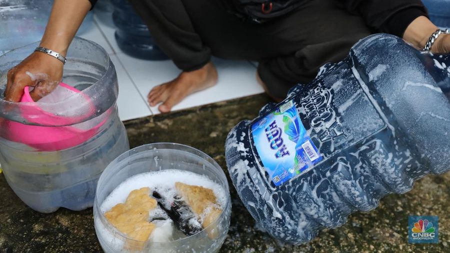 Pekerja mengisi air isi ulang galon di kawasan Depok, Jawa Barat, Selasa (28/10/2025). (CNBC Indonesia/Tri Susilo)
