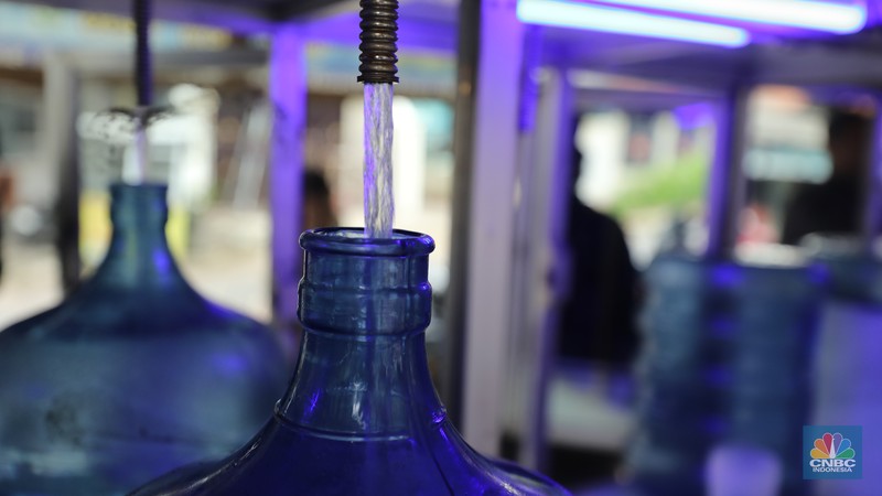 Pekerja mengisi air isi ulang galon di kawasan Depok, Jawa Barat, Selasa (28/10/2025). (CNBC Indonesia/Tri Susilo)