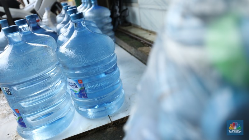 Pekerja mengisi air isi ulang galon di kawasan Depok, Jawa Barat, Selasa (28/10/2025). (CNBC Indonesia/Tri Susilo)