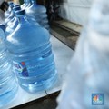 Pekerja mengisi air isi ulang galon di kawasan Depok, Jawa Barat, Selasa (28/10/2025). (CNBC Indonesia/Tri Susilo)