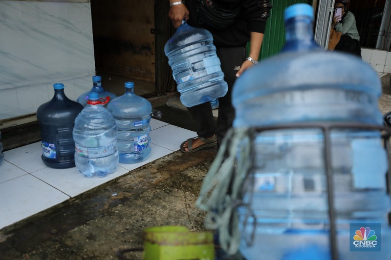 Pekerja mengisi air isi ulang galon di kawasan Depok, Jawa Barat, Selasa (28/10/2025). (CNBC Indonesia/Tri Susilo)