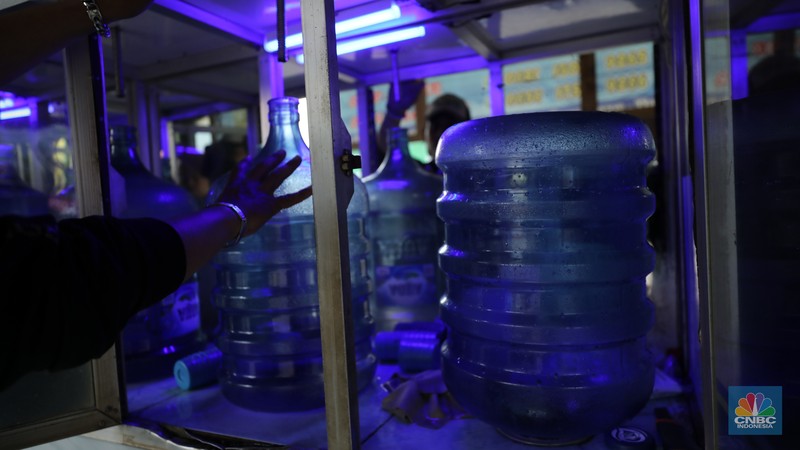 Pekerja mengisi air isi ulang galon di kawasan Depok, Jawa Barat, Selasa (28/10/2025). (CNBC Indonesia/Tri Susilo)