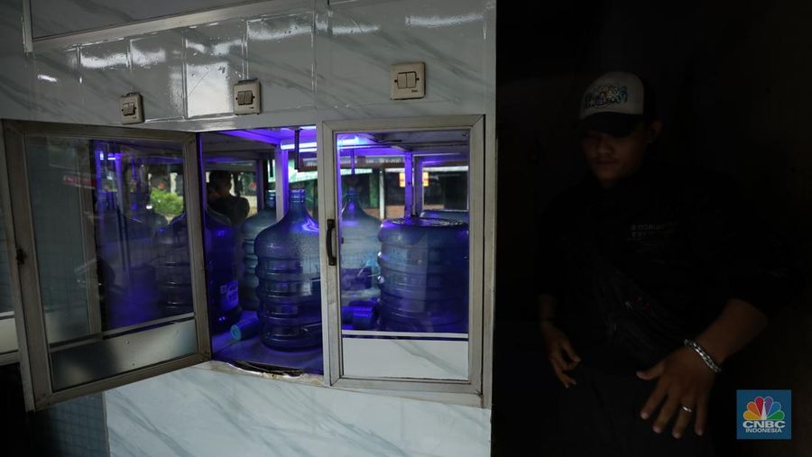 Pekerja mengisi air isi ulang galon di kawasan Depok, Jawa Barat, Selasa (28/10/2025). (CNBC Indonesia/Tri Susilo)