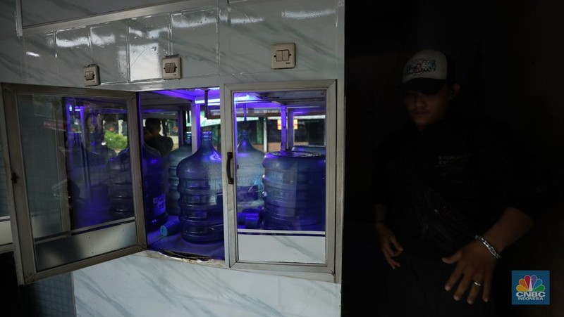 Pekerja mengisi air isi ulang galon di kawasan Depok, Jawa Barat, Selasa (28/10/2025). (CNBC Indonesia/Tri Susilo)
