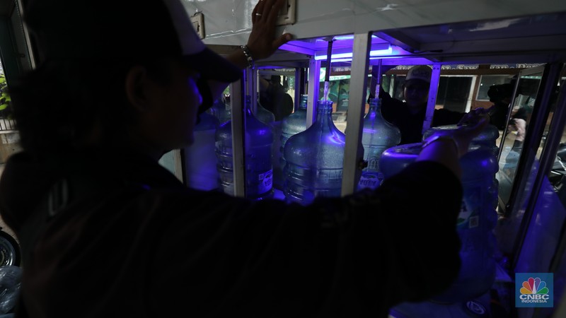 Pekerja mengisi air isi ulang galon di kawasan Depok, Jawa Barat, Selasa (28/10/2025). (CNBC Indonesia/Tri Susilo)