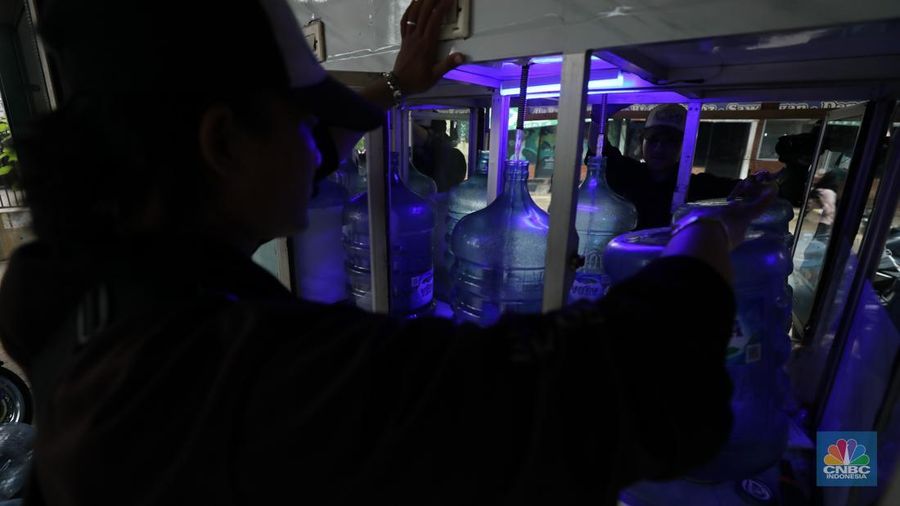 Pekerja mengisi air isi ulang galon di kawasan Depok, Jawa Barat, Selasa (28/10/2025). (CNBC Indonesia/Tri Susilo)
