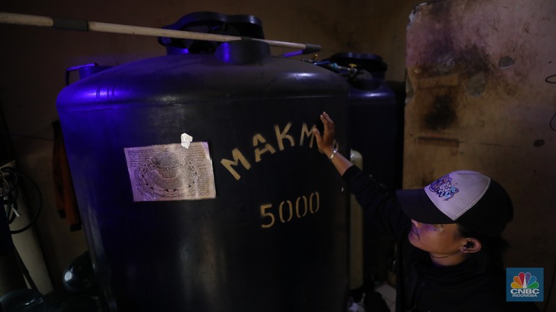 Pekerja mengisi air isi ulang galon di kawasan Depok, Jawa Barat, Selasa (28/10/2025). (CNBC Indonesia/Tri Susilo)