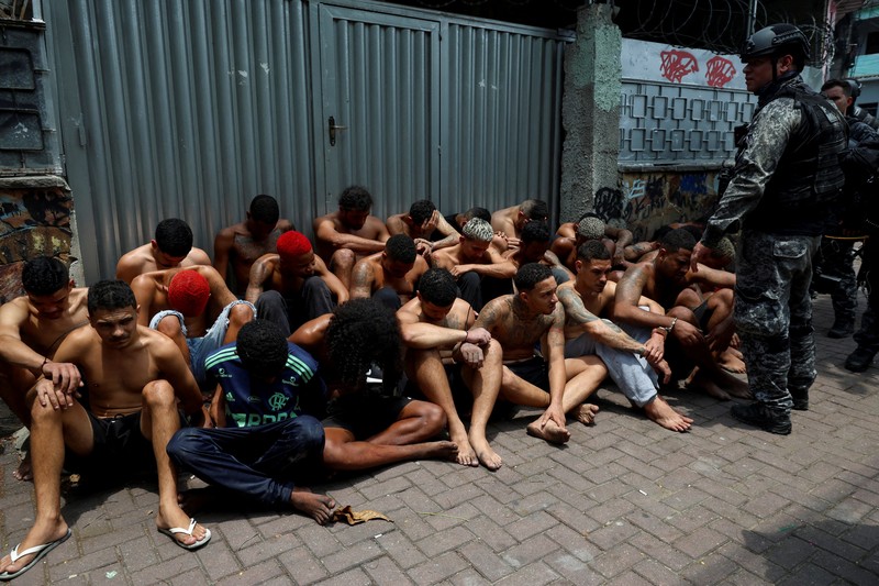 BRAZIL-VIOLENCE/ A man is detained by police officers during a police operation against drug trafficking at the favela do Penha, in Rio de Janeiro, Brazil October 28, 2025. REUTERS/Aline Massuca