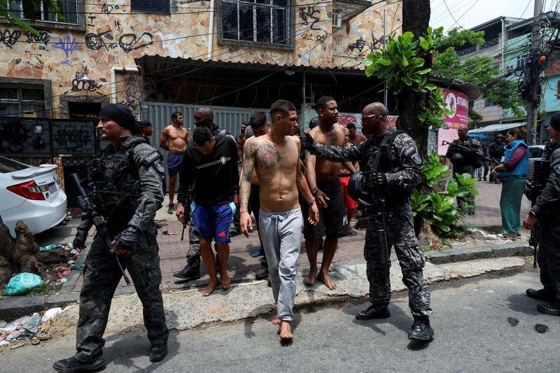 BRAZIL-VIOLENCE/ A man is detained by police officers during a police operation against drug trafficking at the favela do Penha, in Rio de Janeiro, Brazil October 28, 2025. REUTERS/Aline Massuca