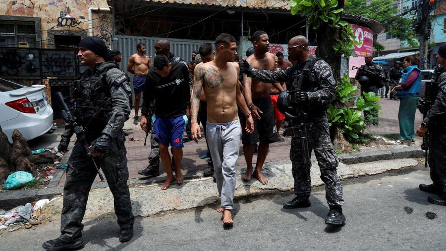 A man is detained by police officers during a police operation against drug trafficking at the favela do Penha, in Rio de Janeiro, Brazil October 28, 2025. REUTERS/Aline Massuca