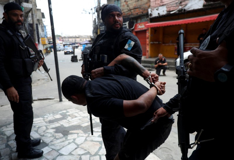 BRAZIL-VIOLENCE/ A man is detained by police officers during a police operation against drug trafficking at the favela do Penha, in Rio de Janeiro, Brazil October 28, 2025. REUTERS/Aline Massuca
