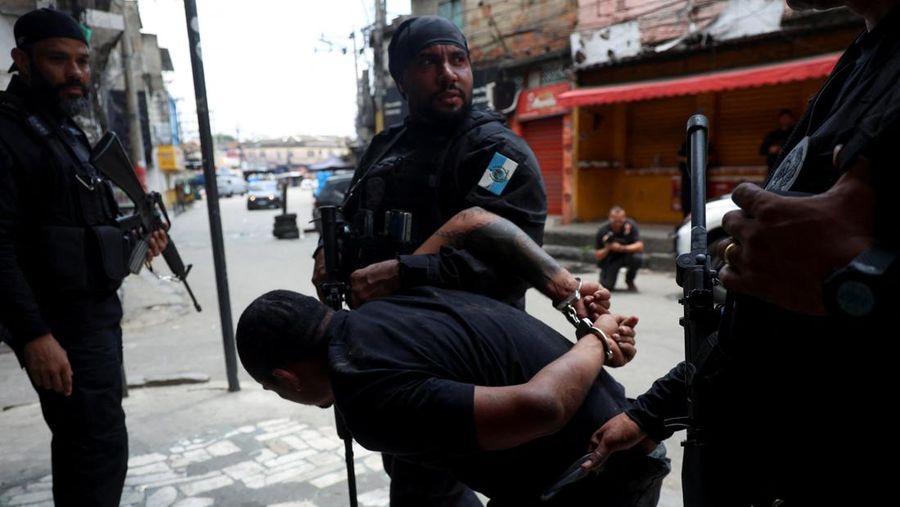 A man is detained by police officers during a police operation against drug trafficking at the favela do Penha, in Rio de Janeiro, Brazil October 28, 2025. REUTERS/Aline Massuca