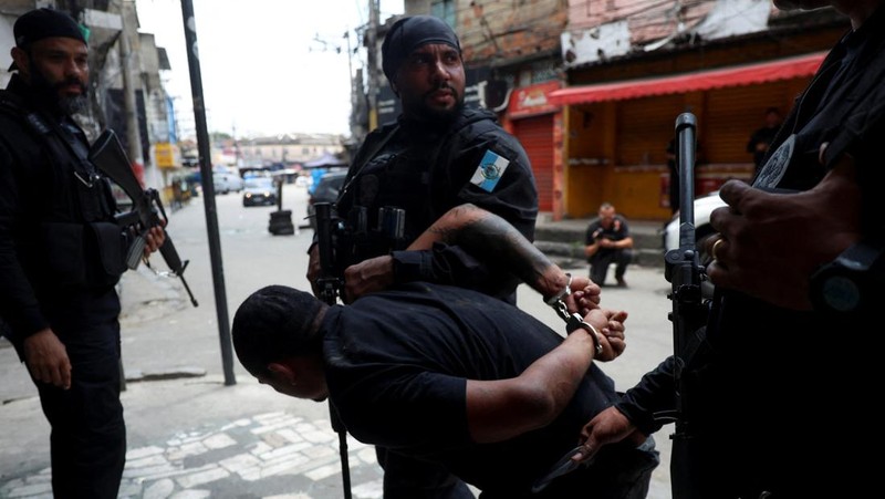 A man is detained by police officers during a police operation against drug trafficking at the favela do Penha, in Rio de Janeiro, Brazil October 28, 2025. REUTERS/Aline Massuca