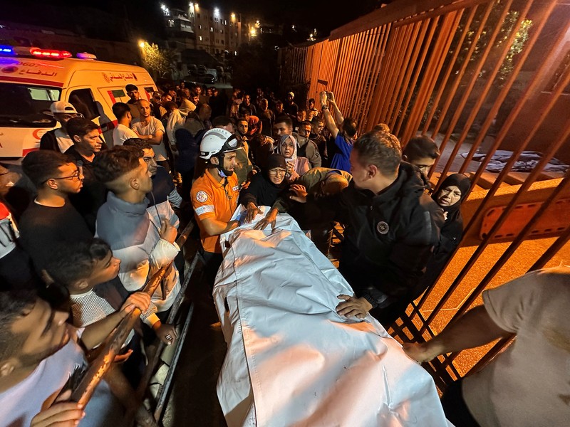 ISRAEL-PALESTINIANS/GAZA Seorang pria Palestina bereaksi di samping jenazah seorang pria, yang menurut petugas medis tewas dalam serangan Israel, di Rumah Sakit Nasser di Khan Younis, Jalur Gaza selatan, 28 Oktober 2025. REUTERS/Stringer