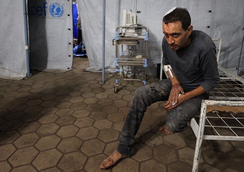 ISRAEL-PALESTINIANS/GAZA Seorang pria Palestina bereaksi di samping jenazah seorang pria, yang menurut petugas medis tewas dalam serangan Israel, di Rumah Sakit Nasser di Khan Younis, Jalur Gaza selatan, 28 Oktober 2025. REUTERS/Stringer