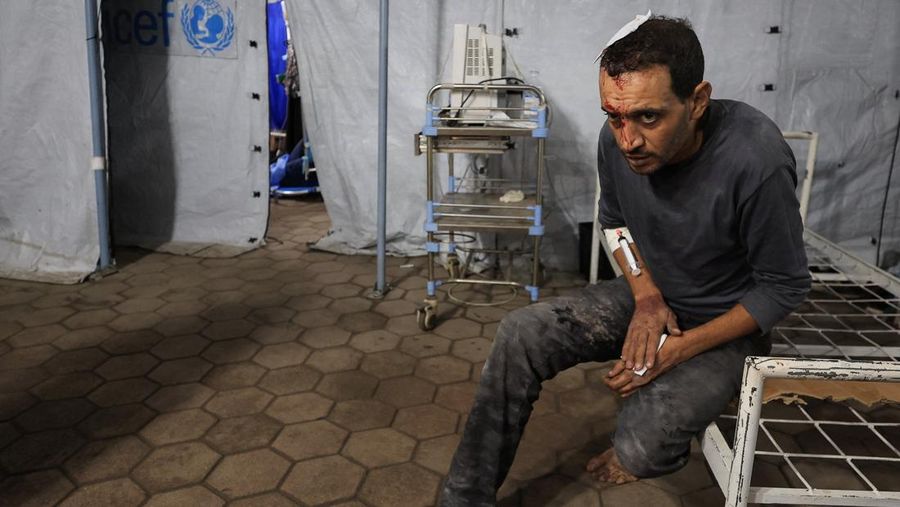 ISRAEL-PALESTINIANS/GAZA Seorang pria Palestina bereaksi di samping jenazah seorang pria, yang menurut petugas medis tewas dalam serangan Israel, di Rumah Sakit Nasser di Khan Younis, Jalur Gaza selatan, 28 Oktober 2025. REUTERS/Stringer