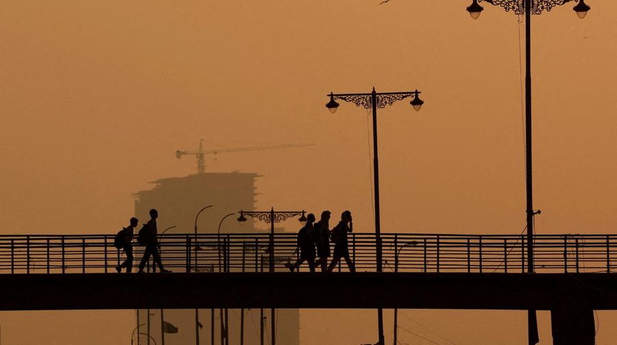 Para siswa terlihat siluetnya saat menyeberangi jembatan penyeberangan di tengah kabut asap dan polusi udara di pagi hari, di Karachi, Pakistan, 29 Oktober 2025. Para siswa terlihat siluetnya saat menyeberangi jembatan penyeberangan di tengah kabut asap dan polusi udara di pagi hari, di Karachi, Pakistan, 29 Oktober 2025. (REUTERS/Akhtar Soomro)