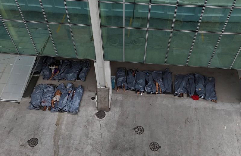 SENSITIVE MATERIAL. THIS IMAGE MAY OFFEND OR DISTURB A mourner kisses a covered body, the day after a deadly police operation against drug trafficking at the favela do Penha, in Rio de Janeiro, Brazil, October 29, 2025. REUTERS/Ricardo Moraes     TPX IMAGES OF THE DAY