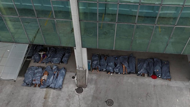 BRAZIL-VIOLENCE/ SENSITIVE MATERIAL. THIS IMAGE MAY OFFEND OR DISTURB A mourner kisses a covered body, the day after a deadly police operation against drug trafficking at the favela do Penha, in Rio de Janeiro, Brazil, October 29, 2025. REUTERS/Ricardo Moraes     TPX IMAGES OF THE DAY