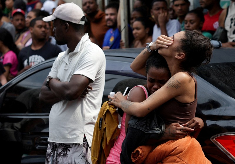 SENSITIVE MATERIAL. THIS IMAGE MAY OFFEND OR DISTURB A mourner kisses a covered body, the day after a deadly police operation against drug trafficking at the favela do Penha, in Rio de Janeiro, Brazil, October 29, 2025. REUTERS/Ricardo Moraes     TPX IMAGES OF THE DAY