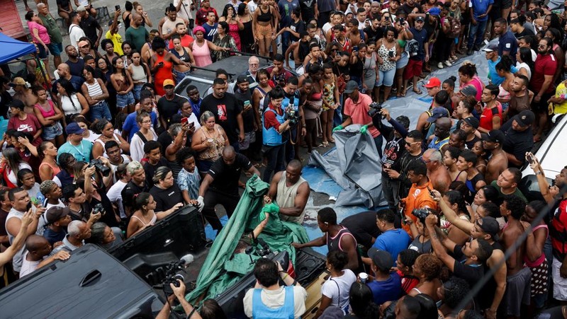 BRAZIL-VIOLENCE/ SENSITIVE MATERIAL. THIS IMAGE MAY OFFEND OR DISTURB A mourner kisses a covered body, the day after a deadly police operation against drug trafficking at the favela do Penha, in Rio de Janeiro, Brazil, October 29, 2025. REUTERS/Ricardo Moraes     TPX IMAGES OF THE DAY