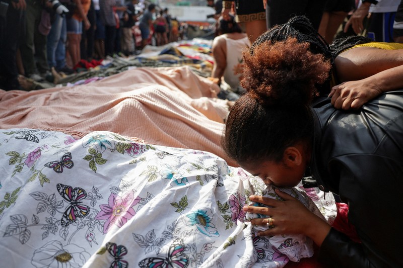 SENSITIVE MATERIAL. THIS IMAGE MAY OFFEND OR DISTURB A mourner kisses a covered body, the day after a deadly police operation against drug trafficking at the favela do Penha, in Rio de Janeiro, Brazil, October 29, 2025. REUTERS/Ricardo Moraes     TPX IMAGES OF THE DAY