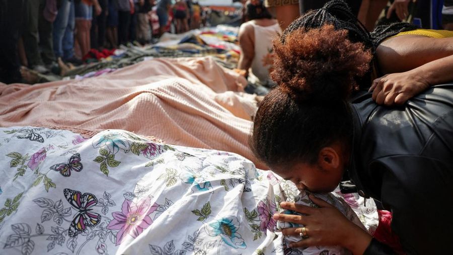BRAZIL-VIOLENCE/ SENSITIVE MATERIAL. THIS IMAGE MAY OFFEND OR DISTURB A mourner kisses a covered body, the day after a deadly police operation against drug trafficking at the favela do Penha, in Rio de Janeiro, Brazil, October 29, 2025. REUTERS/Ricardo Moraes     TPX IMAGES OF THE DAY