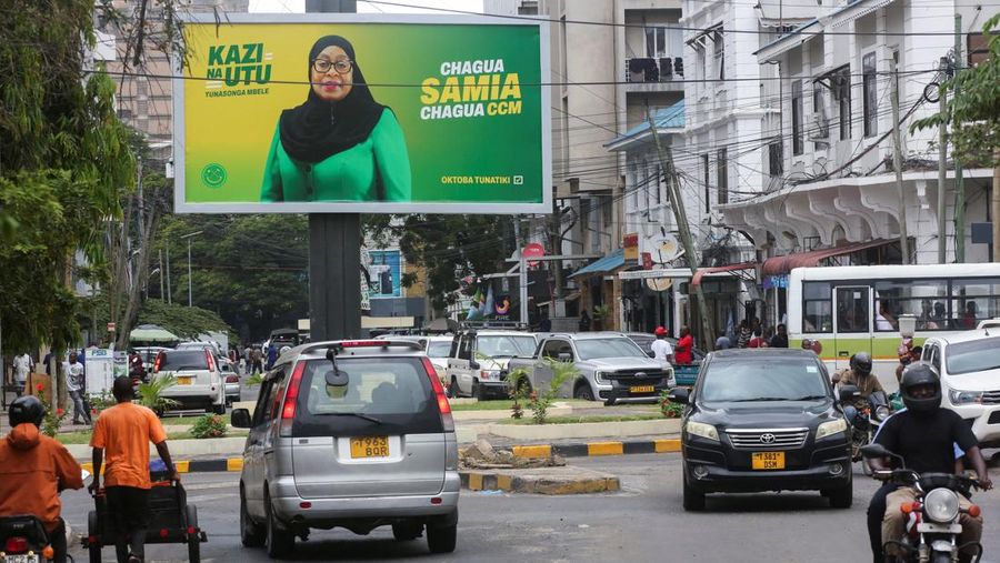Pengendara melewati papan iklan kampanye pemilu Presiden Tanzania Samia Suluhu Hassan dari Partai berkuasa Chama Cha Mapinduzi (CCM) menjelang pemilihan umum di distrik Ilala, Dar es Salaam, Tanzania, 28 Oktober 2025. (REUTERS/Emmanuel Herman)