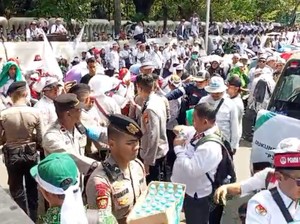 Polisi Bagi-bagi Air Mineral dan Roti ke Guru Pendemo di Monas