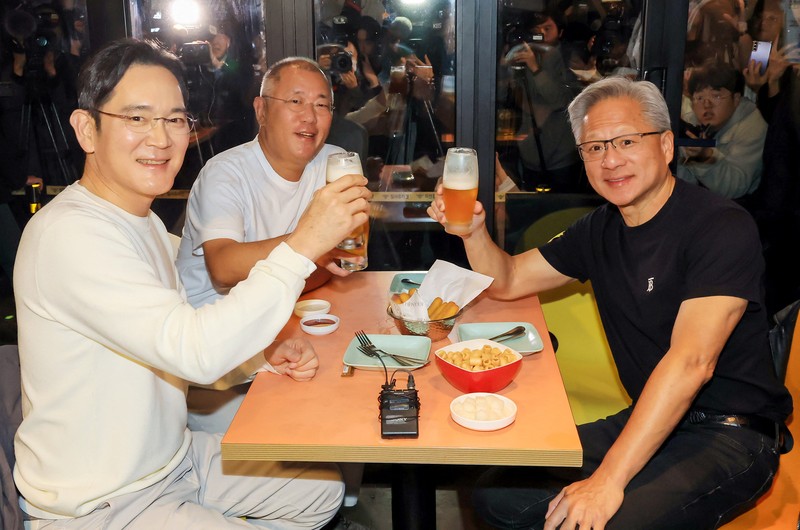 NVIDIA-SOUTHKOREA/ CEO Nvidia Jensen Huang memberikan hadiah kepada Chairman Samsung Electronics Jay Y. Lee dan Chairman Eksekutif Hyundai Motor Group Euisun Chung dalam sebuah pertemuan makan malam di sebuah restoran ayam goreng di Seoul, Korea Selatan, 30 Oktober 2025. Yonhap via REUTERS.