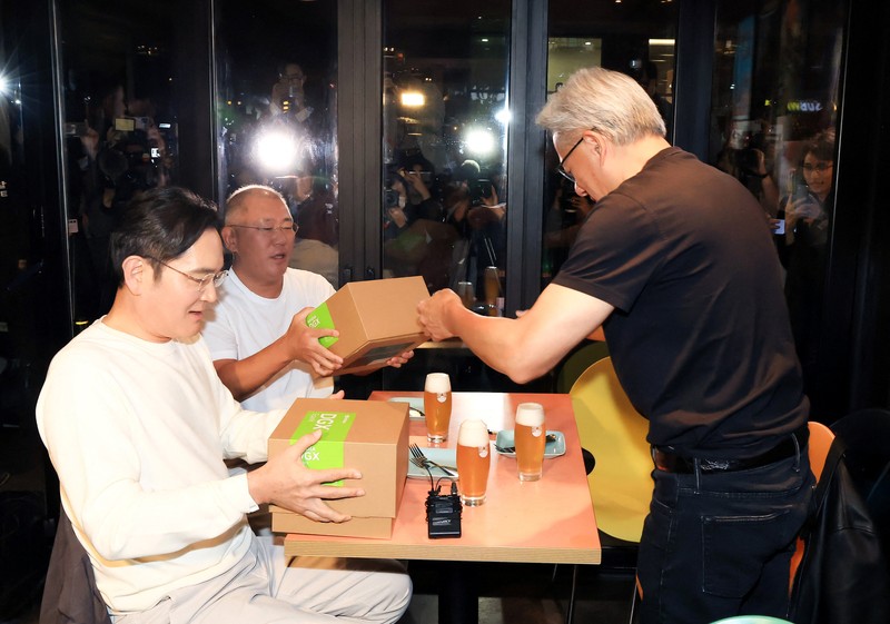 NVIDIA-SOUTHKOREA/ CEO Nvidia Jensen Huang memberikan hadiah kepada Chairman Samsung Electronics Jay Y. Lee dan Chairman Eksekutif Hyundai Motor Group Euisun Chung dalam sebuah pertemuan makan malam di sebuah restoran ayam goreng di Seoul, Korea Selatan, 30 Oktober 2025. Yonhap via REUTERS.