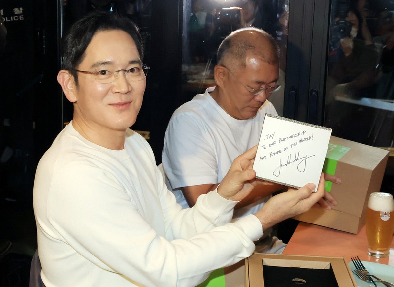 NVIDIA-SOUTHKOREA/ CEO Nvidia Jensen Huang memberikan hadiah kepada Chairman Samsung Electronics Jay Y. Lee dan Chairman Eksekutif Hyundai Motor Group Euisun Chung dalam sebuah pertemuan makan malam di sebuah restoran ayam goreng di Seoul, Korea Selatan, 30 Oktober 2025. Yonhap via REUTERS.