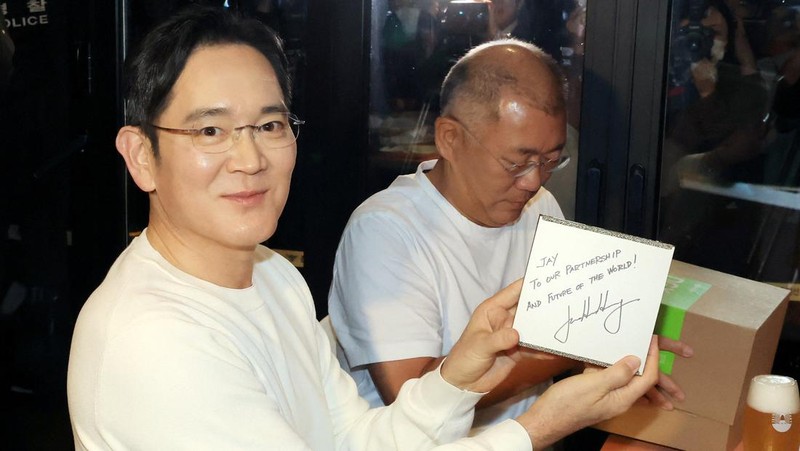 NVIDIA-SOUTHKOREA/ CEO Nvidia Jensen Huang memberikan hadiah kepada Chairman Samsung Electronics Jay Y. Lee dan Chairman Eksekutif Hyundai Motor Group Euisun Chung dalam sebuah pertemuan makan malam di sebuah restoran ayam goreng di Seoul, Korea Selatan, 30 Oktober 2025. Yonhap via REUTERS.