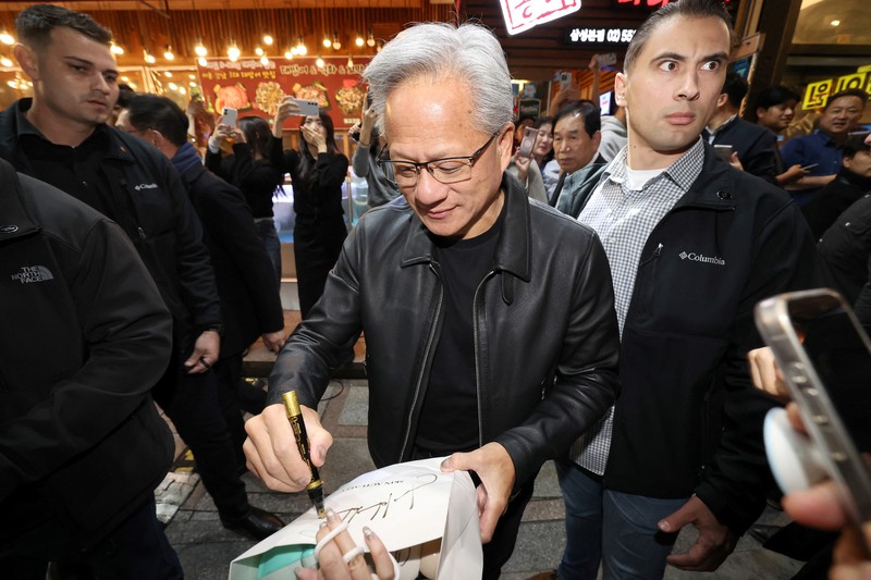 NVIDIA-SOUTHKOREA/ CEO Nvidia Jensen Huang memberikan hadiah kepada Chairman Samsung Electronics Jay Y. Lee dan Chairman Eksekutif Hyundai Motor Group Euisun Chung dalam sebuah pertemuan makan malam di sebuah restoran ayam goreng di Seoul, Korea Selatan, 30 Oktober 2025. Yonhap via REUTERS.