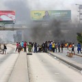 Para demonstran membantu seorang pria yang tertembak dan tewas selama protes keras yang menodai pemilu menyusul diskualifikasi dua kandidat oposisi terkemuka di Dar es Salaam, Tanzania, 29 Oktober 2025. (REUTERS/Onsase Ochando)