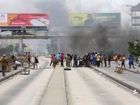 Para demonstran membantu seorang pria yang tertembak dan tewas selama protes keras yang menodai pemilu menyusul diskualifikasi dua kandidat oposisi terkemuka di Dar es Salaam, Tanzania, 29 Oktober 2025. (REUTERS/Onsase Ochando)