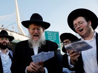 Pria Yahudi Ultra-Ortodoks membaca teks di dekat Jembatan Chords selama protes "Million Man" terhadap wajib militer Israel di Yerusalem, 30 Oktober 2025. (REUTERS/Ammar Awad)