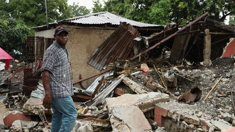 Warga membersihkan lumpur dan puing-puing di luar rumah setelah hujan lebat yang dibawa oleh Badai Melissa menyebabkan banjir mematikan, di Petit Goave, Haiti, 31 Oktober 2025. (REUTERS/Egeder Pq Fildor)