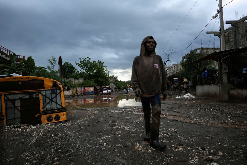 Warga membersihkan lumpur dan puing-puing di luar rumah setelah hujan lebat yang dibawa oleh Badai Melissa menyebabkan banjir mematikan, di Petit Goave, Haiti, 31 Oktober 2025. (REUTERS/Egeder Pq Fildor)