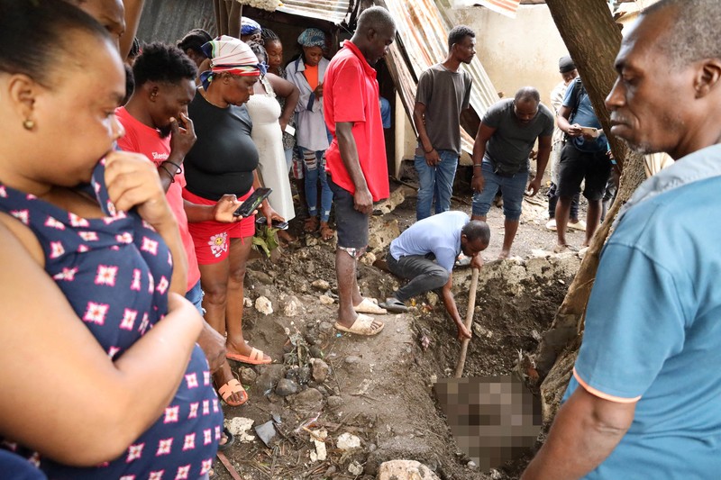 Warga membersihkan lumpur dan puing-puing di luar rumah setelah hujan lebat yang dibawa oleh Badai Melissa menyebabkan banjir mematikan, di Petit Goave, Haiti, 31 Oktober 2025. (REUTERS/Egeder Pq Fildor)