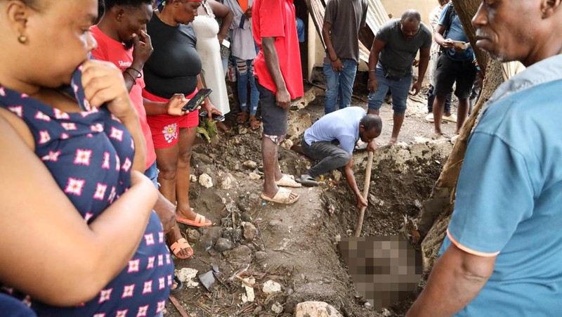 Warga membersihkan lumpur dan puing-puing di luar rumah setelah hujan lebat yang dibawa oleh Badai Melissa menyebabkan banjir mematikan, di Petit Goave, Haiti, 31 Oktober 2025. (REUTERS/Egeder Pq Fildor)