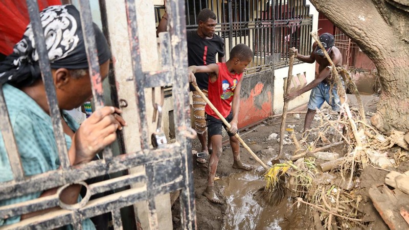 Warga membersihkan lumpur dan puing-puing di luar rumah setelah hujan lebat yang dibawa oleh Badai Melissa menyebabkan banjir mematikan, di Petit Goave, Haiti, 31 Oktober 2025. (REUTERS/Egeder Pq Fildor)