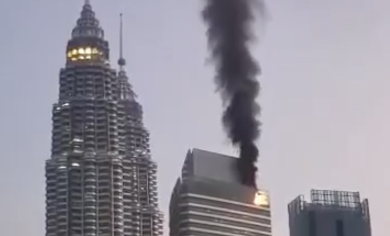 Kebakaran terjadi di gedung Menara Petronas 3, Kuala Lumpur, Malaysia. Foto-foto dan video yang diunggah di media sosial menunjukkan asap tebal mengepul dari puncak gedung tersebut. (Tangkapan Layar Video X/@mohd_escobar)